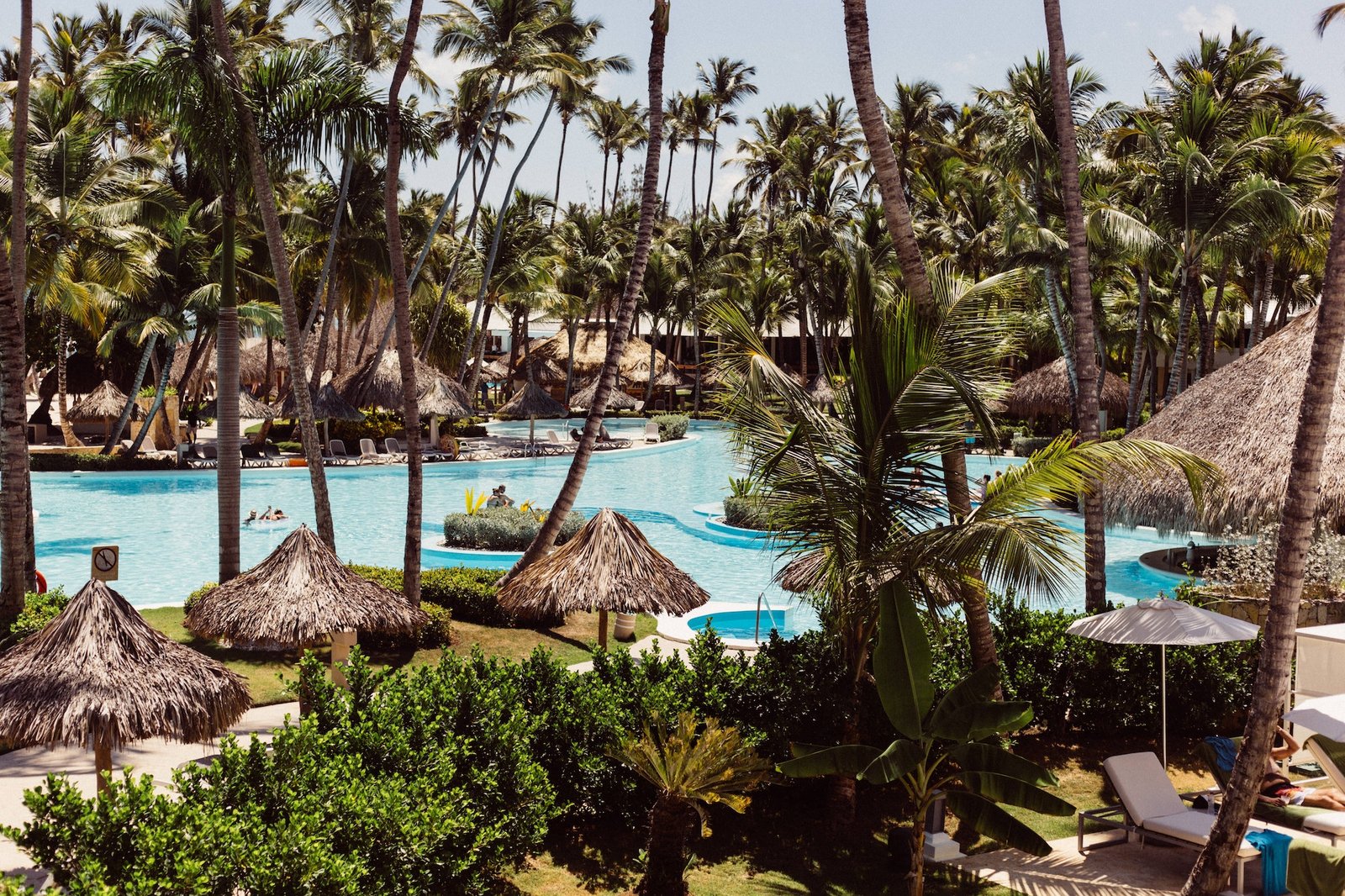 resort pool, leaf umbrellas, and the beach in Punta Cana, Dominican Republic